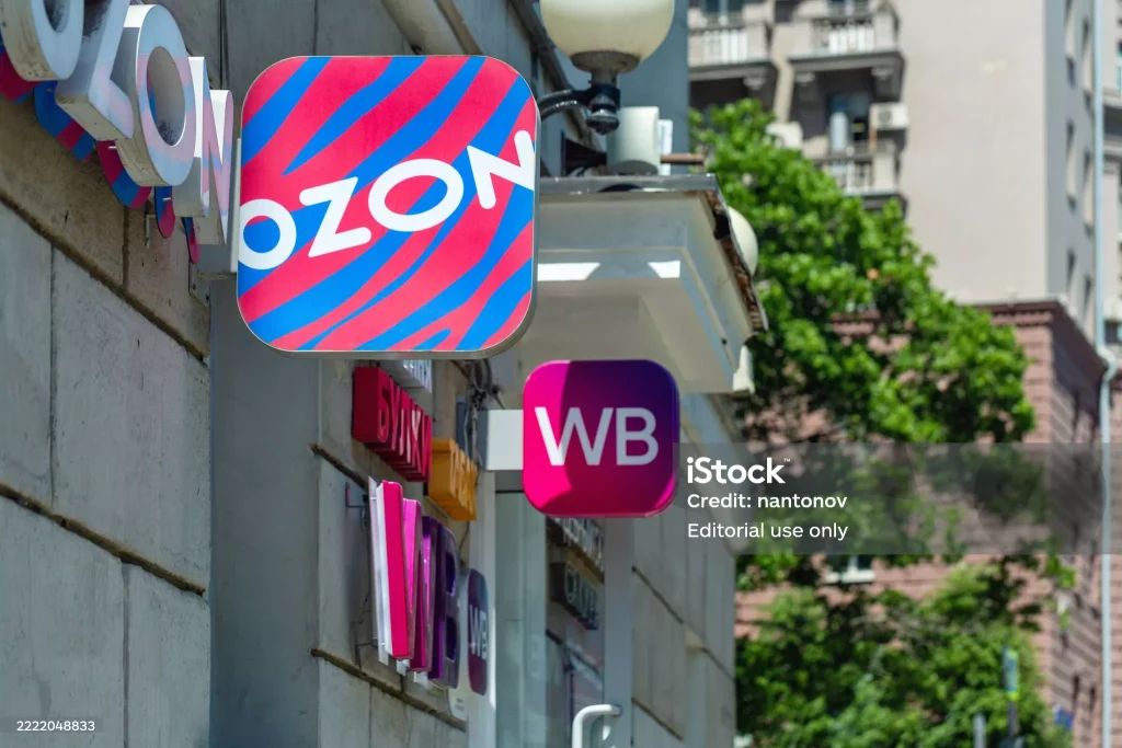 Street-level view of Ozon and Wildberries logos on a building facade in a Russian city, showcasing e-commerce signage.